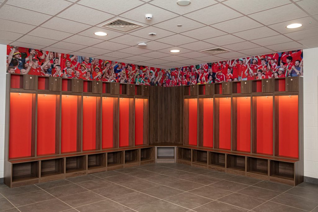 wooden lockers with box cabinets above them in a football changing room